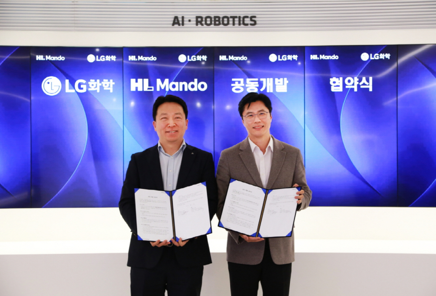왼쪽부터 HL만도 센터장 최한규 상무와 LG화학 전자소재 사업부장 고경덕 상무가 업무협약식을 마치고 기념 촬영을 하고 있다.jpg